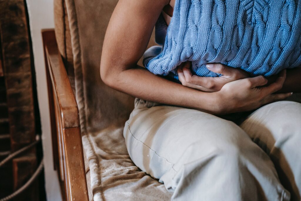 Woman with endometriosis holds her stomach in pain.